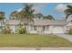 Charming single-story home featuring a metal roof, white exterior, front porch, garage and well-manicured landscaping at 3633 Richboro Dr, Holiday, FL 34691
