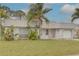 Attractive home featuring a metal roof, white siding, lush front yard, and attached one car garage and quaint porch at 3633 Richboro Dr, Holiday, FL 34691
