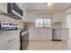 Bright kitchen featuring white cabinetry, tile backsplash, stainless steel appliances, and large window, offering a modern feel at 3633 Richboro Dr, Holiday, FL 34691