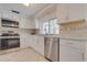 Well-lit kitchen featuring stainless steel appliances, white cabinets, a neutral backsplash, and plenty of counter space at 3633 Richboro Dr, Holiday, FL 34691