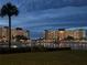 Night view of the condominiums illuminated with holiday lights and a serene lake reflecting the festive ambiance at 4725 Cove Cir # 810, St Petersburg, FL 33708
