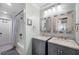 Bathroom featuring double sinks, gray cabinets, fish-themed decor, and a shower with a tub at 4912 W Bay Way Dr, Tampa, FL 33629