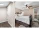 Neutral bedroom featuring an iron bed frame, ceiling fan and an adjacent dressing area at 4912 W Bay Way Dr, Tampa, FL 33629