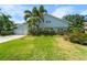 Charming two-story home featuring a lush green lawn, tropical landscaping, and a two-car garage at 4912 W Bay Way Dr, Tampa, FL 33629