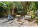 Backyard fire pit area surrounded by tropical vegetation with seating for outdoor enjoyment at 4912 W Bay Way Dr, Tampa, FL 33629