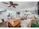 Open-concept living room featuring a large sectional couch, hardwood floors, and a wet bar at 4912 W Bay Way Dr, Tampa, FL 33629