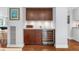 A stylish wet bar area with granite countertops, custom cabinetry, and a modern wine refrigerator at 4912 W Bay Way Dr, Tampa, FL 33629