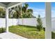 Cozy, fenced backyard featuring green grass, healthy trees, and a stone-tiled patio at 5530 N 9Th St # 1, Tampa, FL 33604