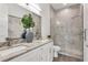 Elegant bathroom featuring double vanity, stylish mirrors, and glass-enclosed shower with marble-look tiles at 5530 N 9Th St # 1, Tampa, FL 33604