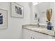 Elegant powder room featuring a granite countertop, stylish faucet, modern mirror and decorative artwork at 5530 N 9Th St # 1, Tampa, FL 33604