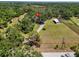 Aerial view of a sprawling home site with trees, a barn, and green pastures at 5870 Jim Davis Rd, Parrish, FL 34219