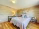 Bedroom featuring wood floors, a wooden accent wall, and a bright window at 5870 Jim Davis Rd, Parrish, FL 34219
