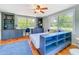 Bedroom with wood floors, custom cabinets, two bright windows, and a blue rug at 5870 Jim Davis Rd, Parrish, FL 34219