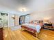 Bedroom with a wooden floor, open closet, dresser, rug and ensuite bathroom with glass-doored shower at 5870 Jim Davis Rd, Parrish, FL 34219