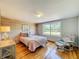 Bedroom with a wooden accent wall, wood floors, a bright window, and a plush chair at 5870 Jim Davis Rd, Parrish, FL 34219