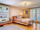 Bedroom with light walls, wood floors, bright window, and light fixture at 5870 Jim Davis Rd, Parrish, FL 34219