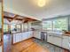 Spacious kitchen with white cabinets, stainless appliances, and island seating that flows into the dining area at 5870 Jim Davis Rd, Parrish, FL 34219