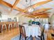 Inviting living room with an open floor plan, exposed wood beams, dining area and kitchen space, and wood flooring at 5870 Jim Davis Rd, Parrish, FL 34219