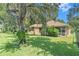 Spacious backyard featuring lush green grass, a screened-in porch, and mature trees at 6130 Whimbrelwood Dr, Lithia, FL 33547