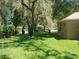 Well-kept lawn with mature trees and glimpse of neighboring homes in a quiet neighborhood at 6130 Whimbrelwood Dr, Lithia, FL 33547