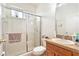 Bathroom with a glass-enclosed shower, single sink vanity, and neutral colored tiling at 6130 Whimbrelwood Dr, Lithia, FL 33547
