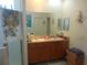 Bathroom featuring a double sink vanity, large mirror, and glass-enclosed shower at 6130 Whimbrelwood Dr, Lithia, FL 33547