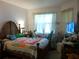 Bedroom with vintage decor, including a wood-framed bed and a window with lace curtains at 6130 Whimbrelwood Dr, Lithia, FL 33547