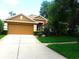 Charming single-story home featuring a well-maintained lawn, beautiful landscaping, and a two-car garage at 6130 Whimbrelwood Dr, Lithia, FL 33547