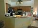 View of the kitchen with wooden cabinets and an adjacent breakfast bar at 6130 Whimbrelwood Dr, Lithia, FL 33547
