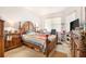 Main bedroom with a wooden bed frame, side table, and natural light from the window at 6130 Whimbrelwood Dr, Lithia, FL 33547