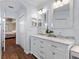 Bright bathroom featuring dual sink vanity, wood floors, and neutral paint at 6230 Gannetdale Dr, Lithia, FL 33547
