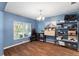Dining room with natural light, wood floors, modern light fixture, and blue walls at 6230 Gannetdale Dr, Lithia, FL 33547