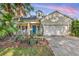 Charming home featuring a blue front door, landscaped garden, and a two-car garage in a desirable neighborhood at 6230 Gannetdale Dr, Lithia, FL 33547