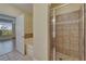 Bathroom with a white tub, travertine tile, and a shower featuring a glass door at 6451 Sunset Bay Cir, Apollo Beach, FL 33572