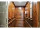 A residential elevator featuring wood-paneled walls, a classic telephone, and a control panel at 6451 Sunset Bay Cir, Apollo Beach, FL 33572