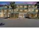 A yellow, three-story townhouse shows the entry and attached garages, under a green roof at 6451 Sunset Bay Cir, Apollo Beach, FL 33572