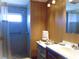 This bathroom features a shower with grey tiling, a sink with a white countertop, and wood-paneled walls at 652 54Th S Ln # 153, Gulfport, FL 33707