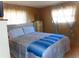 Bedroom with bed featuring a blue blanket, two side tables, and two large windows at 652 54Th S Ln # 153, Gulfport, FL 33707