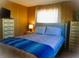 Bedroom with bed featuring a blue blanket, two side tables, and two large windows at 652 54Th S Ln # 153, Gulfport, FL 33707