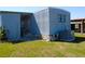 Exterior view of home with blue siding, an air conditioning unit, and a well-maintained lawn at 652 54Th S Ln # 153, Gulfport, FL 33707