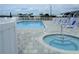 Community pool and hot tub surrounded by lounge chairs and white fencing at 652 54Th S Ln # 153, Gulfport, FL 33707