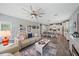 Open-concept living room with dining and kitchen features a ceiling fan and tile flooring at 7338 Milestone Dr, Apollo Beach, FL 33572