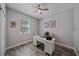 Bright office with gray wood-look tile flooring, ceiling fan, and white desk at 7338 Milestone Dr, Apollo Beach, FL 33572