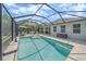 Screened-in pool with travertine deck and outdoor seating area, perfect for entertaining at 7338 Milestone Dr, Apollo Beach, FL 33572
