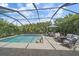 Inviting screened-in pool featuring in-pool seating and a relaxing outdoor lounge area at 7338 Milestone Dr, Apollo Beach, FL 33572