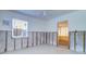 Unfinished bedroom featuring a ceiling fan, window, concrete block walls, and doorway leading to an enclosed porch at 763 182Nd E Ave, Redington Shores, FL 33708