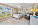 Well-lit bedroom with a queen bed, a large window offering outdoor views, and a cozy sitting area at 8244 Brentwood Rd, Seminole, FL 33777