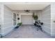 A welcoming entrance patio with seating, a ceiling fan, and front door that leads to an attached garage at 8244 Brentwood Rd, Seminole, FL 33777
