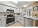 Modern kitchen features stainless steel appliances, white cabinets, and bright countertops for a sleek look at 8244 Brentwood Rd, Seminole, FL 33777