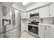 The bright kitchen features stainless steel appliances, white cabinets, and light countertops for a clean aesthetic at 8244 Brentwood Rd, Seminole, FL 33777